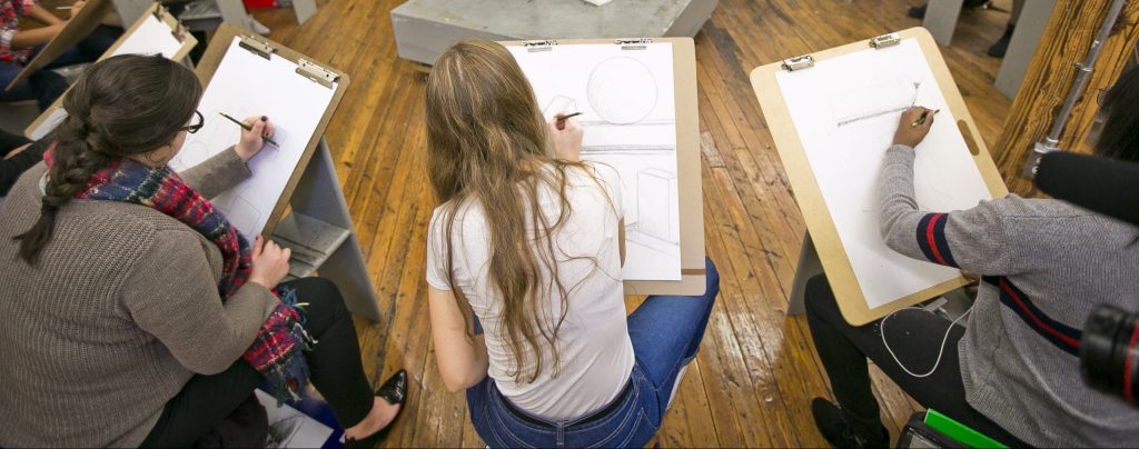 Undergraduate students drawing in an art class.